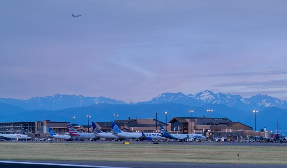 multiple aircraft parked at terminal, early morning before sunrise