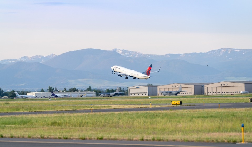 Delta Aircraft taking off over GA hangars
